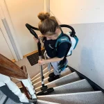 Kvindelig medarbejder fra Midtjysk Facility Service støvsuger trapper.